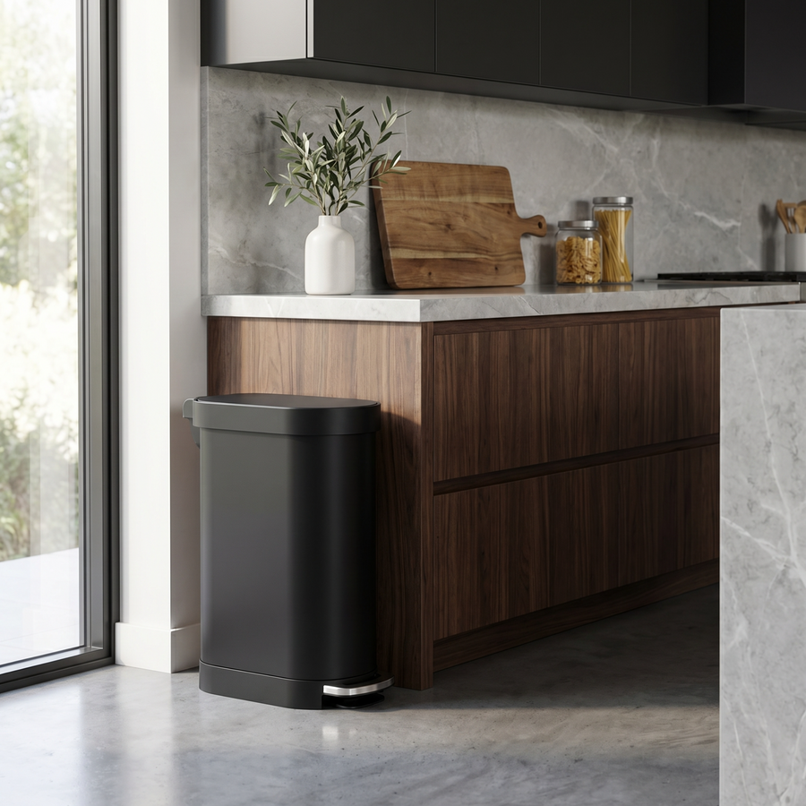 Simplehuman's Slim Step Can in Matte Black in a rustic kitchen setting.