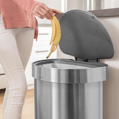45L semi-round pedal bin with liner rim - brushed finish - lifestyle lid open woman throwing away banana image